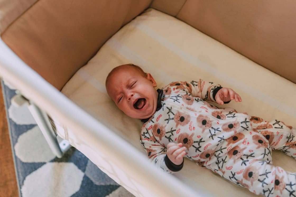 colicky baby crying in a crib